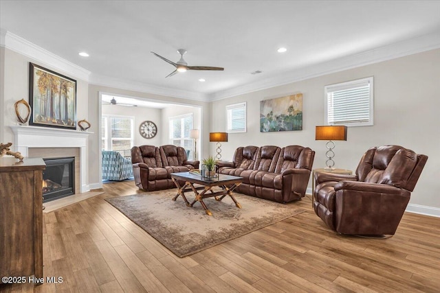 living room with crown molding, ceiling fan, and light hardwood / wood-style floors