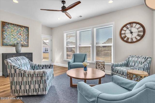 living room with wood-type flooring and ceiling fan