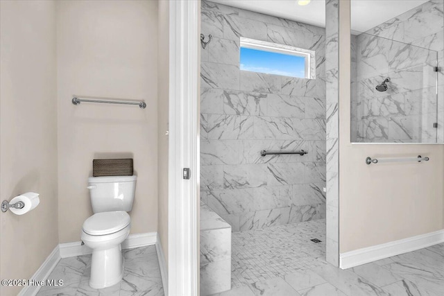 bathroom featuring a tile shower and toilet