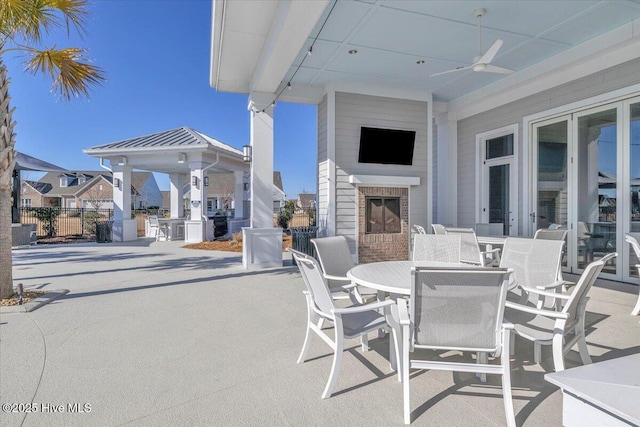 view of patio with an outdoor brick fireplace and ceiling fan