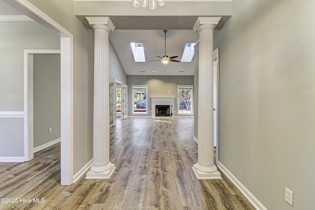 hall with ornate columns, wood-type flooring, and high vaulted ceiling