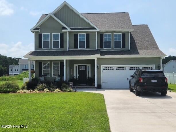 craftsman-style house with a garage, a front yard, and covered porch