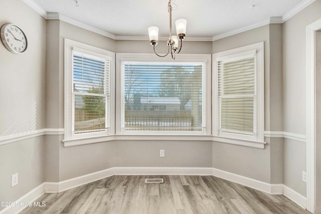 unfurnished dining area featuring an inviting chandelier, baseboards, and wood finished floors