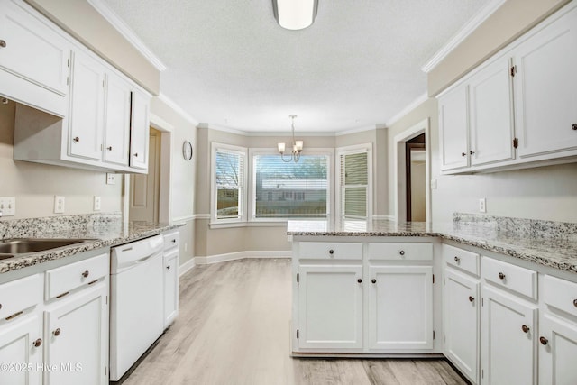 kitchen with a peninsula, ornamental molding, white cabinets, and dishwasher