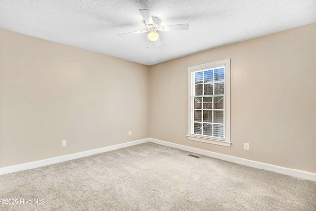 carpeted empty room with ceiling fan and a textured ceiling