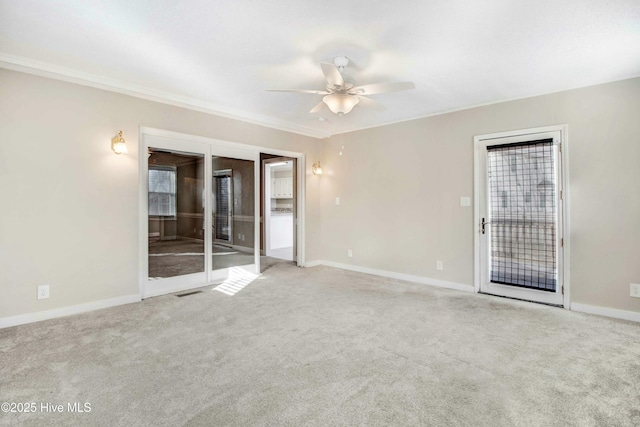 unfurnished room with ceiling fan, carpet floors, ornamental molding, and baseboards