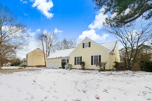 snow covered property featuring a garage