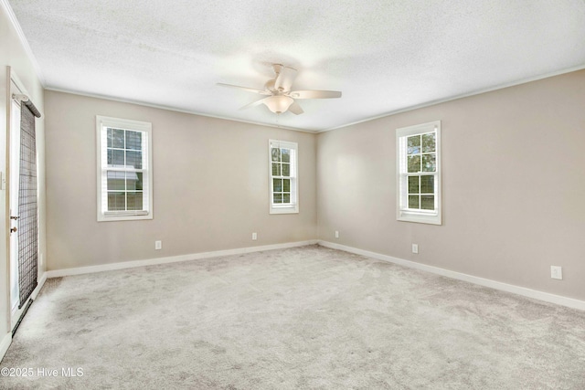 empty room with carpet, baseboards, ceiling fan, and a textured ceiling