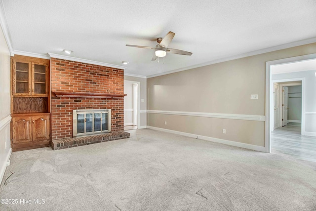 unfurnished living room featuring ornamental molding, light colored carpet, a textured ceiling, and a fireplace