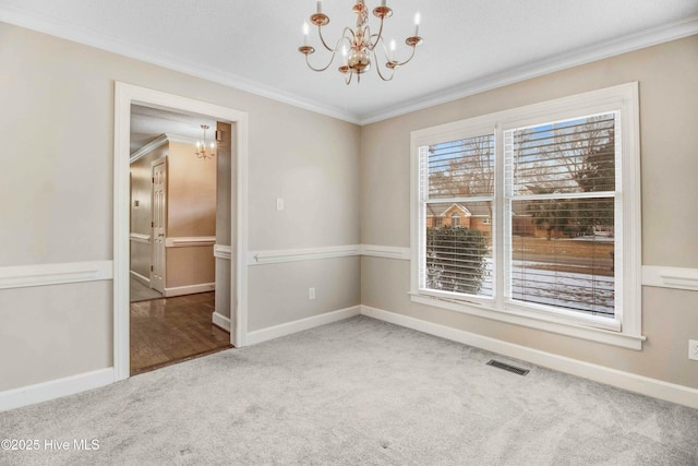 empty room with carpet, visible vents, a chandelier, and crown molding