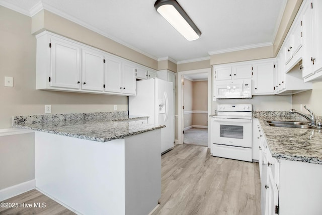 kitchen featuring a peninsula, white appliances, a sink, light wood-style floors, and light stone countertops