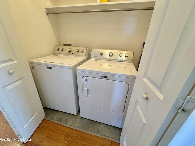 laundry room with separate washer and dryer and light hardwood / wood-style flooring