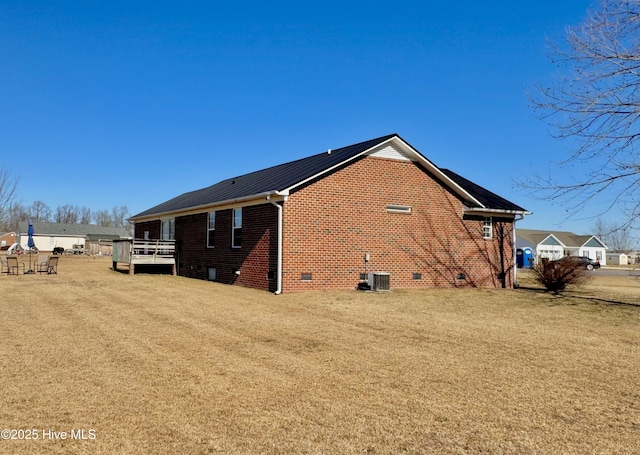 view of home's exterior with a wooden deck, central AC, and a lawn