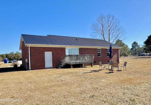 back of house featuring a wooden deck and a yard