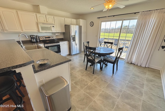 kitchen featuring white cabinetry, sink, stainless steel appliances, and a textured ceiling