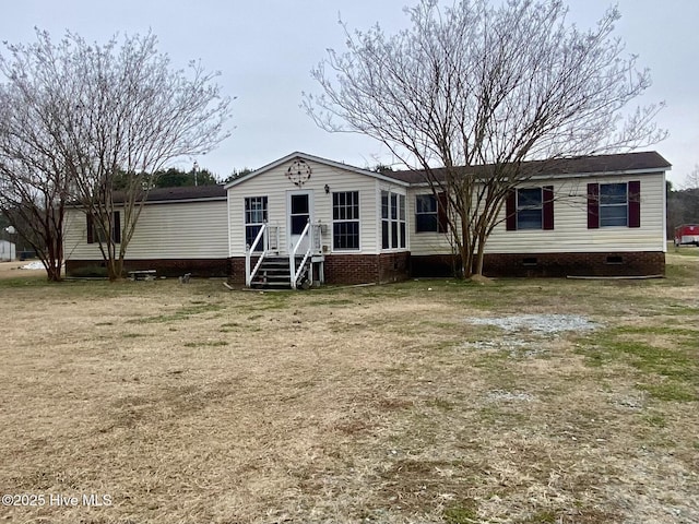 rear view of property featuring a lawn