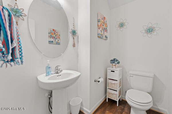 bathroom featuring hardwood / wood-style flooring and toilet