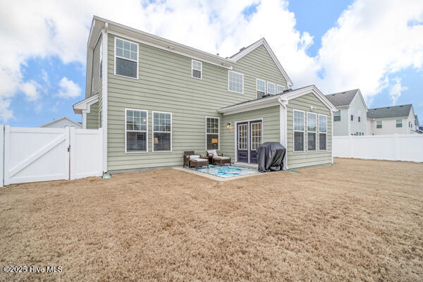 back of house with a yard and a patio area