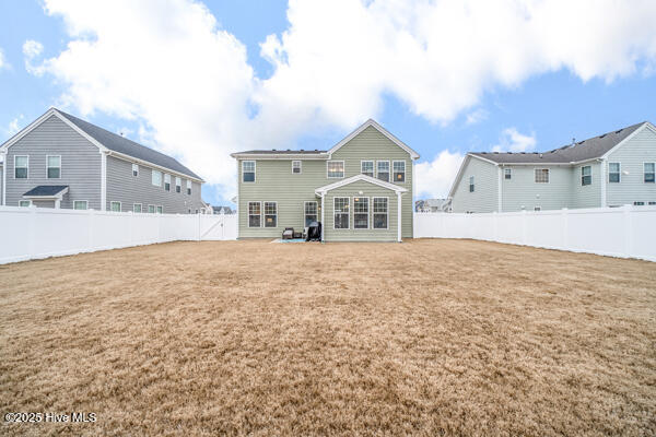 rear view of property featuring a lawn