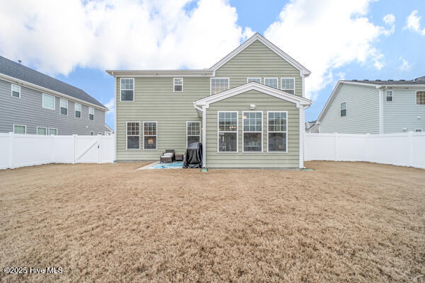 back of house featuring a patio area and a lawn