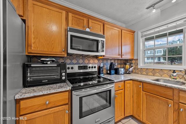 kitchen featuring decorative backsplash, light stone countertops, and appliances with stainless steel finishes