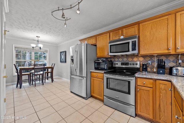 kitchen featuring tasteful backsplash, light tile patterned floors, light stone counters, stainless steel appliances, and crown molding