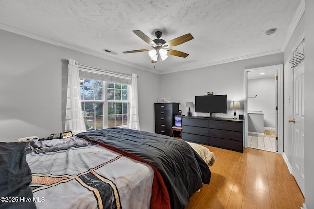 bedroom featuring crown molding, ceiling fan, a textured ceiling, and light wood-type flooring