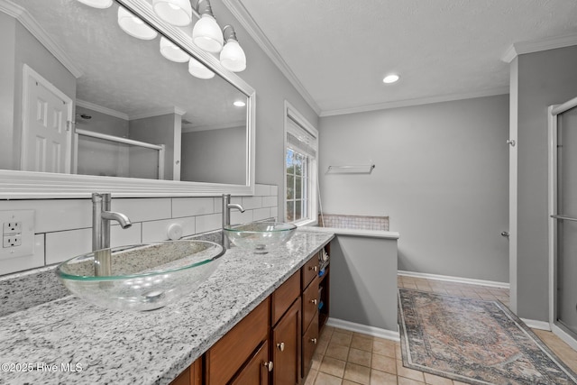 bathroom with tile patterned floors, a shower with shower door, ornamental molding, vanity, and backsplash