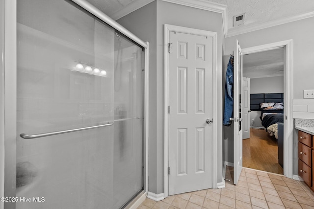 bathroom with a shower with shower door, tile patterned flooring, vanity, crown molding, and a textured ceiling