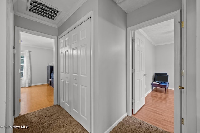 corridor with ornamental molding and wood-type flooring