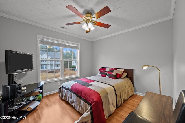 bedroom featuring crown molding, a textured ceiling, and light wood-type flooring