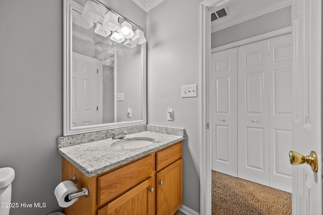 bathroom with crown molding, vanity, and toilet