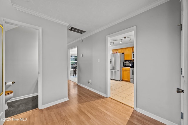 hallway featuring crown molding, track lighting, and light hardwood / wood-style floors