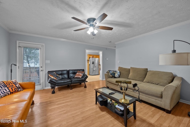 living room featuring ceiling fan, light hardwood / wood-style flooring, and a textured ceiling