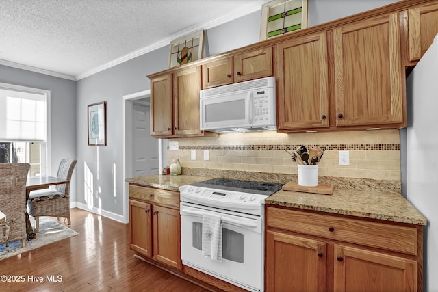 kitchen featuring crown molding, white appliances, hardwood / wood-style flooring, backsplash, and a textured ceiling