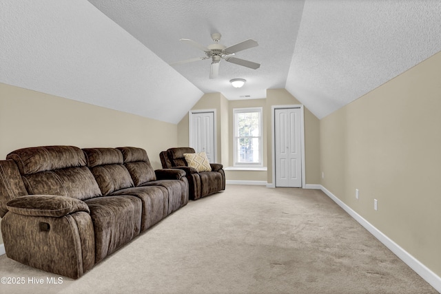 carpeted living room featuring vaulted ceiling, ceiling fan, and a textured ceiling