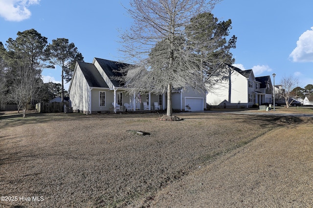 view of front of home featuring a garage, a front yard, and covered porch