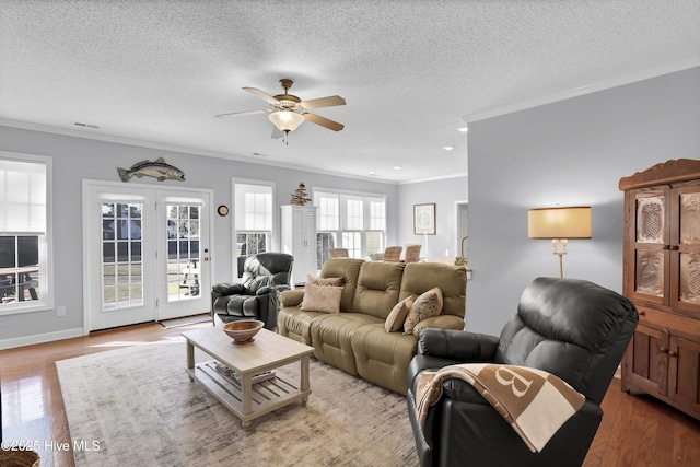 living room featuring ornamental molding, light hardwood / wood-style floors, and a textured ceiling