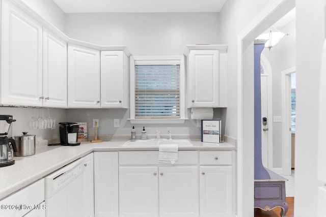 kitchen featuring dishwasher, sink, and white cabinets