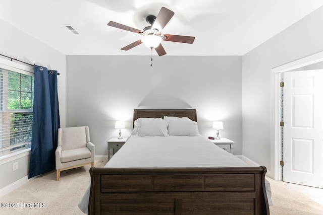 carpeted bedroom featuring multiple windows and ceiling fan