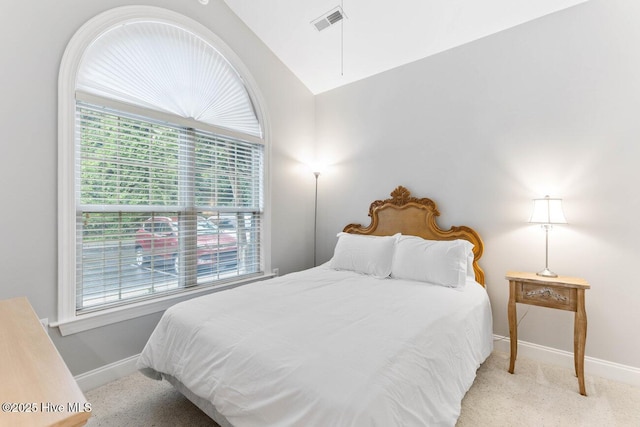 bedroom featuring lofted ceiling and light carpet