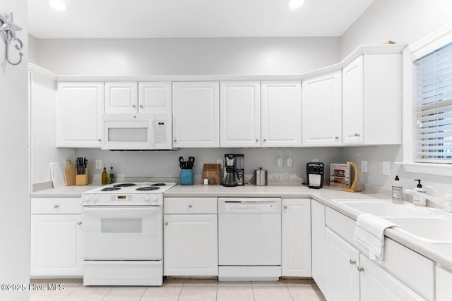 kitchen with white appliances, sink, and white cabinets