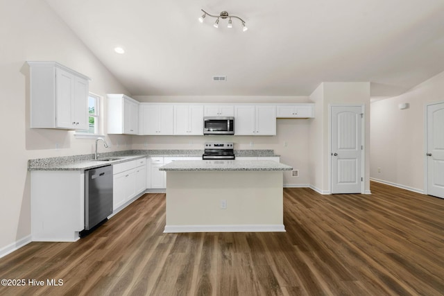 kitchen featuring appliances with stainless steel finishes, white cabinets, a sink, baseboards, and dark wood-type flooring
