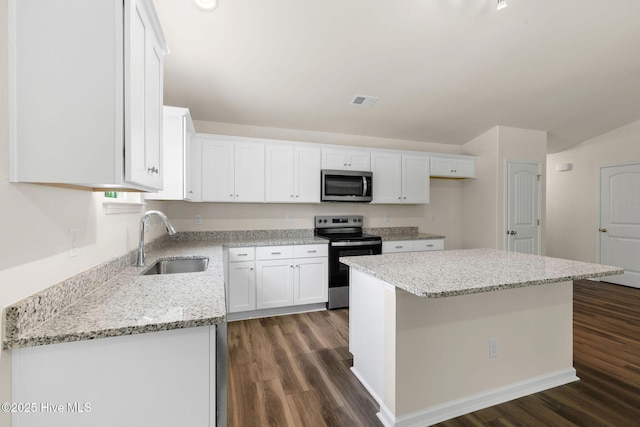 kitchen featuring light stone counters, appliances with stainless steel finishes, white cabinets, dark wood-style flooring, and a sink