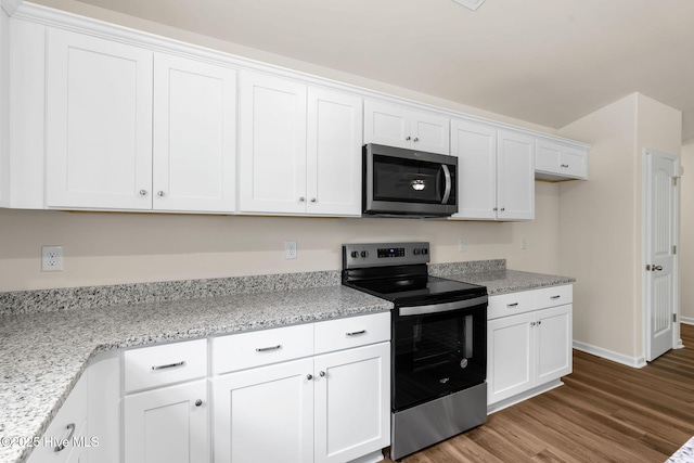 kitchen featuring white cabinetry, stainless steel appliances, and wood finished floors