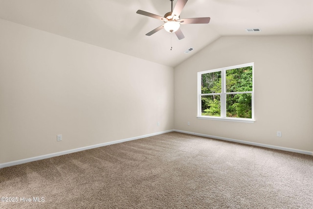 carpeted spare room featuring a ceiling fan, visible vents, vaulted ceiling, and baseboards