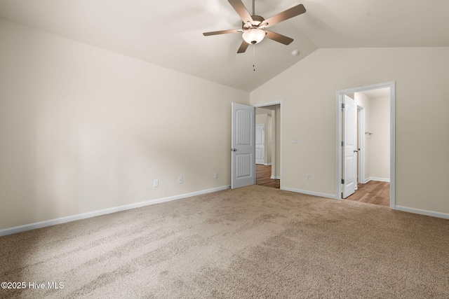 unfurnished bedroom featuring lofted ceiling, baseboards, and carpet floors