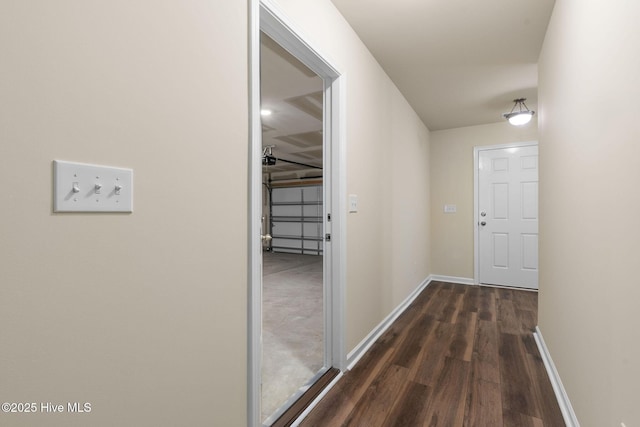 hallway featuring baseboards and dark wood-type flooring