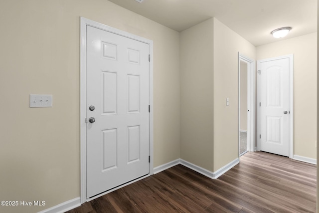 entryway with dark wood-style flooring and baseboards