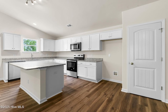 kitchen featuring dark wood-style floors, visible vents, a kitchen island, white cabinetry, and appliances with stainless steel finishes